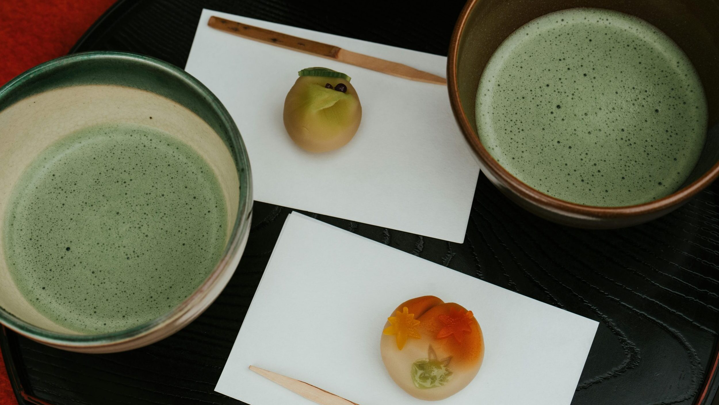Artistic presentation of matcha tea and wagashi sweets in a traditional Japanese tea ceremony setting.