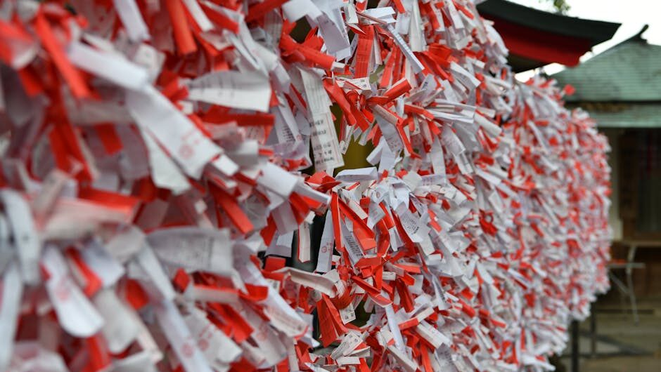 Colorful omikuji fortune papers tied at a Shinto shrine, symbolizing hopes and wishes.